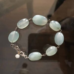 A bracelet with green stones on it