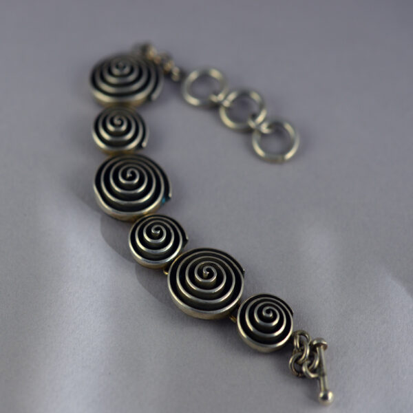 A silver bracelet with circles on it