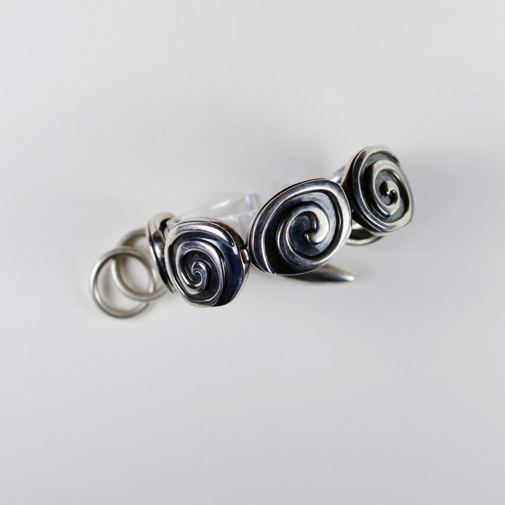 A silver ring with three spirals on it.