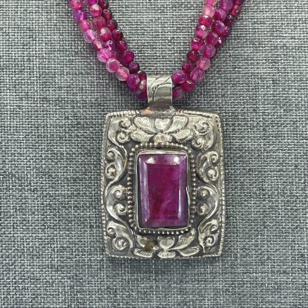 A necklace with a purple stone on it