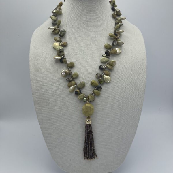 A necklace with green beads and a tassel.