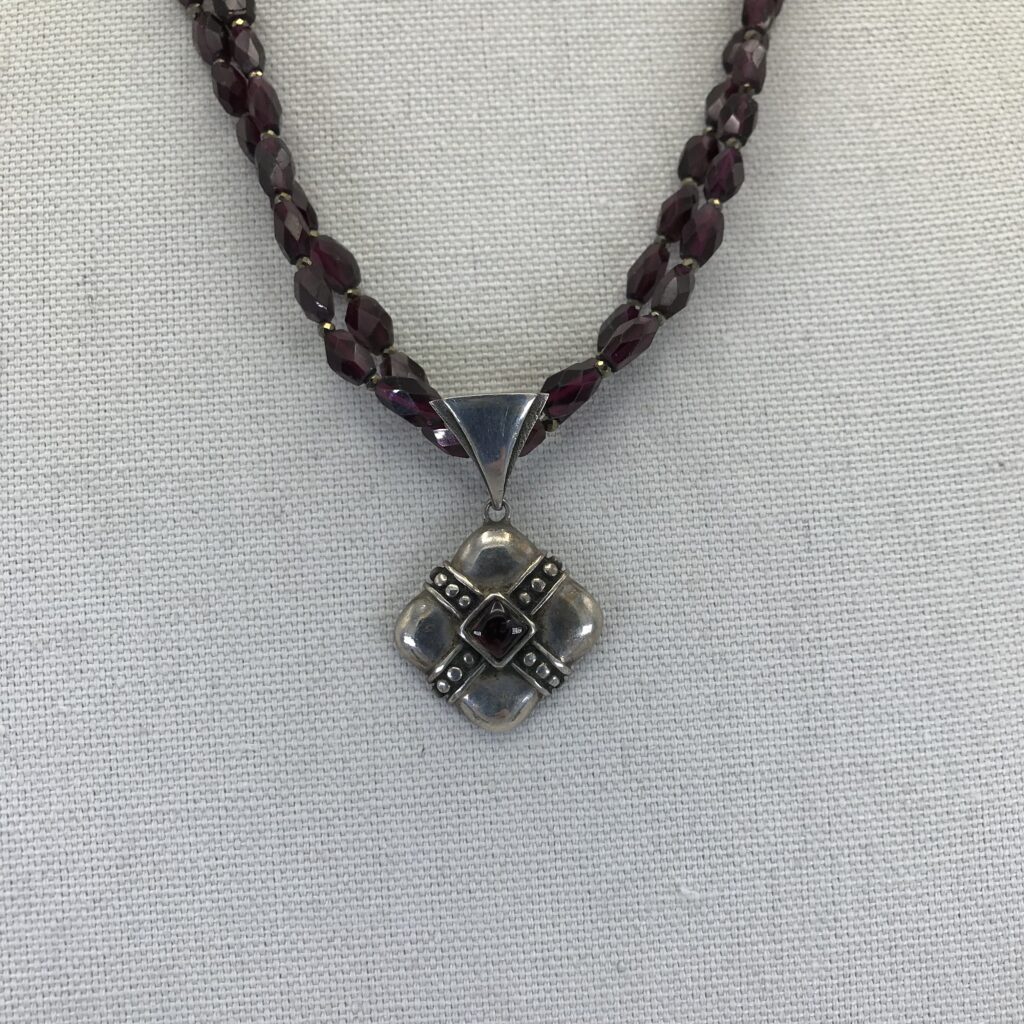 A necklace with a silver pendant on it