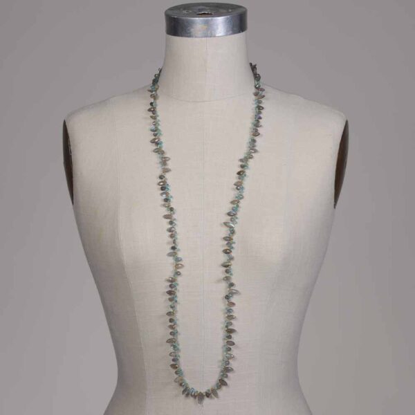 A mannequin wearing a necklace with green beads.