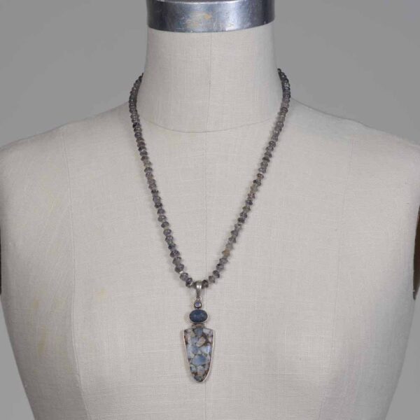 A necklace is shown on the mannequin.