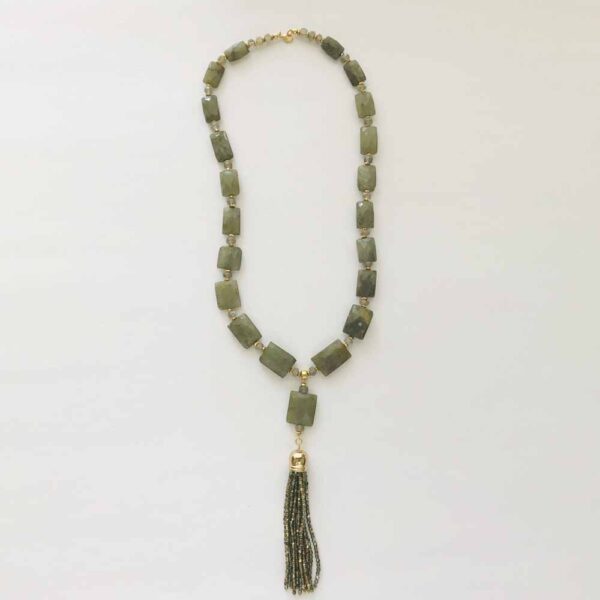 A long necklace with green stones and a tassel.