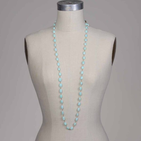 A mannequin wearing a necklace with light blue beads.