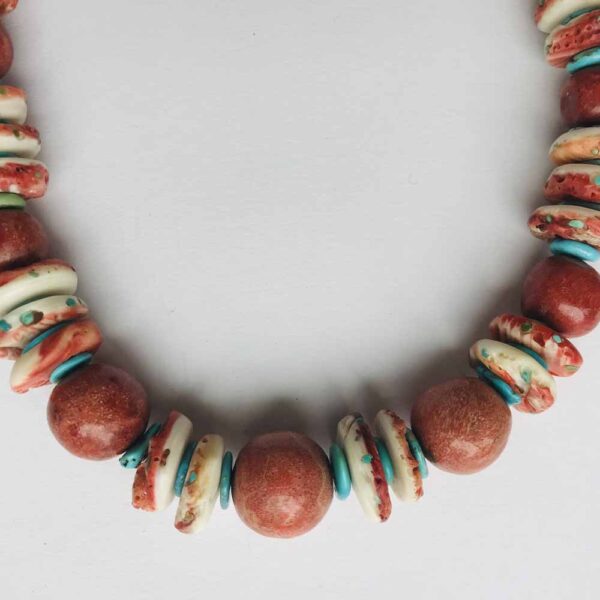 A necklace of red and white beads on a white background