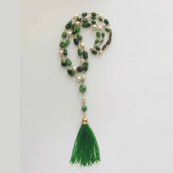 A long necklace with green beads and a tassel.