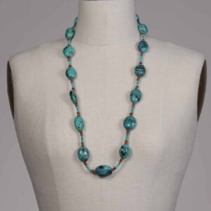 A mannequin wearing a necklace with blue beads.