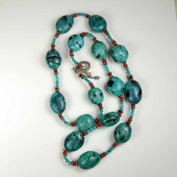 A long necklace of turquoise and red beads.