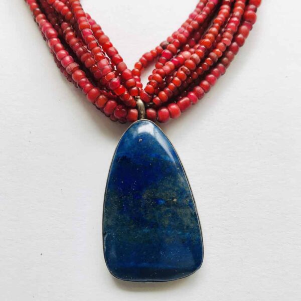 A necklace with red beads and blue stone