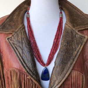 A leather jacket with a blue stone and red beads