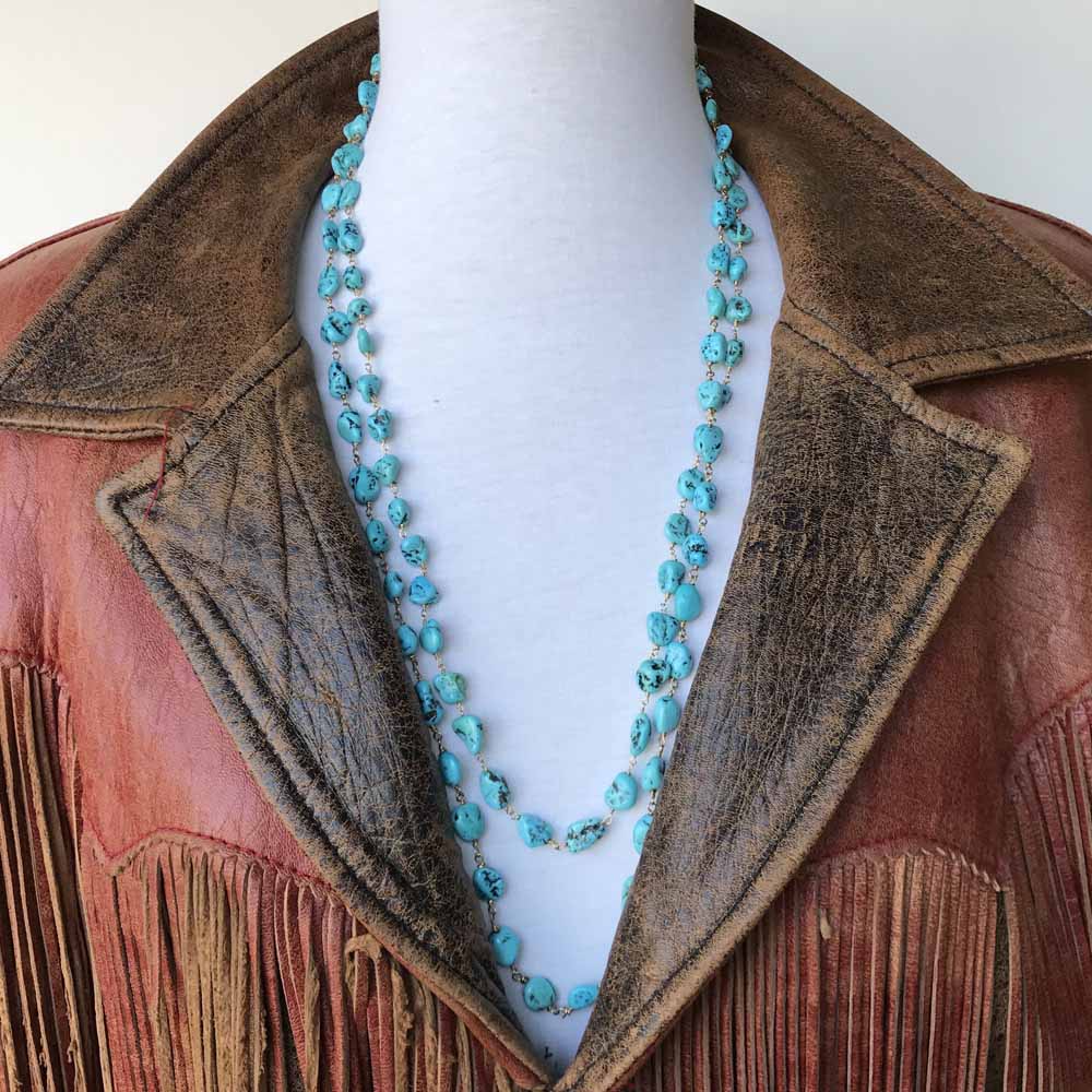 A brown leather jacket with a blue beaded necklace.