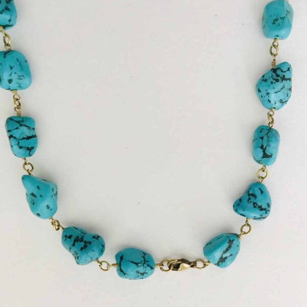 A necklace with turquoise nuggets on it.