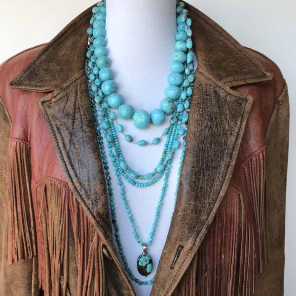 A brown jacket with multiple necklaces and beads