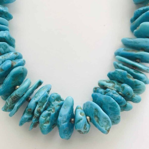 A close up of a necklace with turquoise