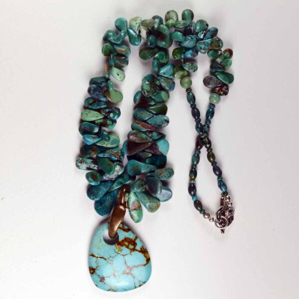 A necklace with turquoise and green beads on it.