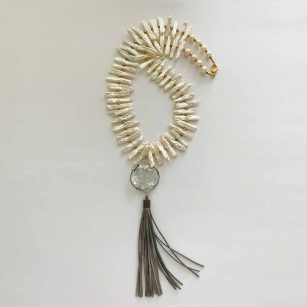 A necklace with a tassel and a round pendant.