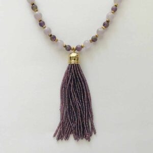 A necklace with a purple tassel and beads.