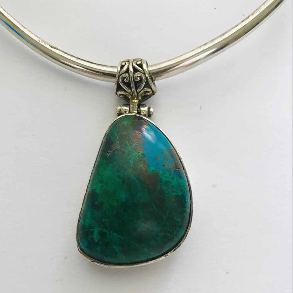 A green stone is hanging on the neck.