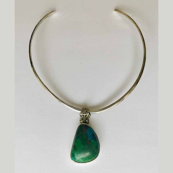 A necklace with a green stone hanging from it.