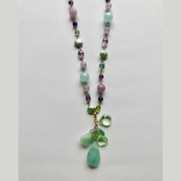 A necklace with green beads and a green stone.