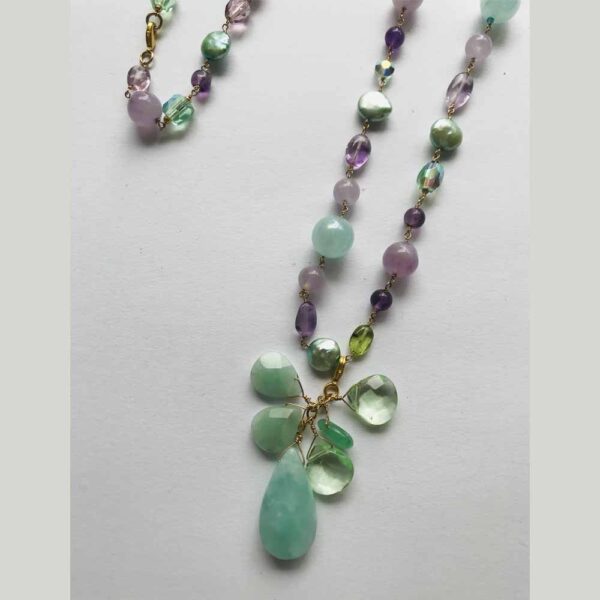 A necklace with green and purple beads on it.