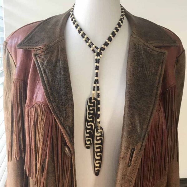 A brown leather jacket with a long necklace.