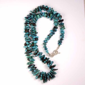 A long turquoise necklace with silver clasp.