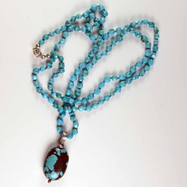 A necklace with turquoise beads and a pendant.