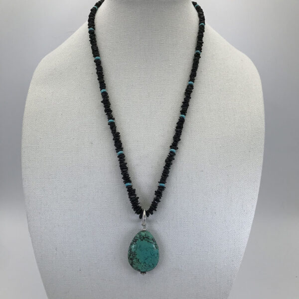 A necklace with a turquoise pendant on it.