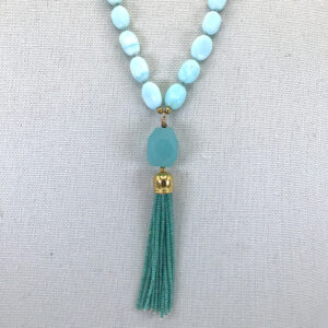 A necklace with a blue bead and tassel.