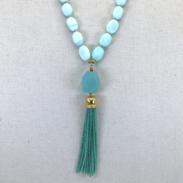 A necklace with a blue bead and tassel.