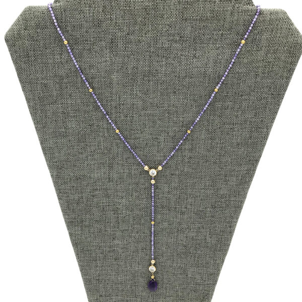 A necklace is shown on display in front of a gray background.