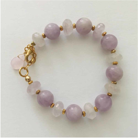 A bracelet with purple and white beads on it.