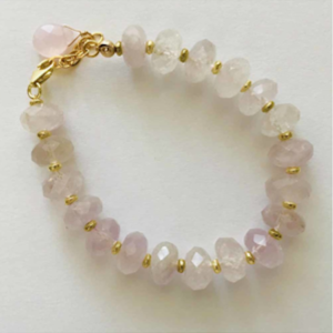 A bracelet with pink beads and gold accents.