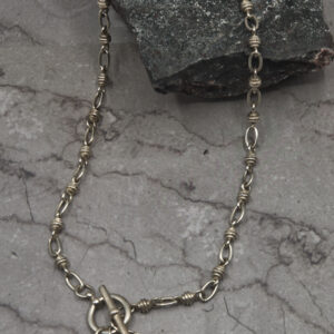 A chain link necklace with an anchor charm.